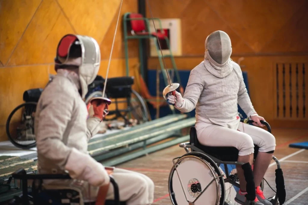 Two disabled friends in wheelchairs enjoying fencing